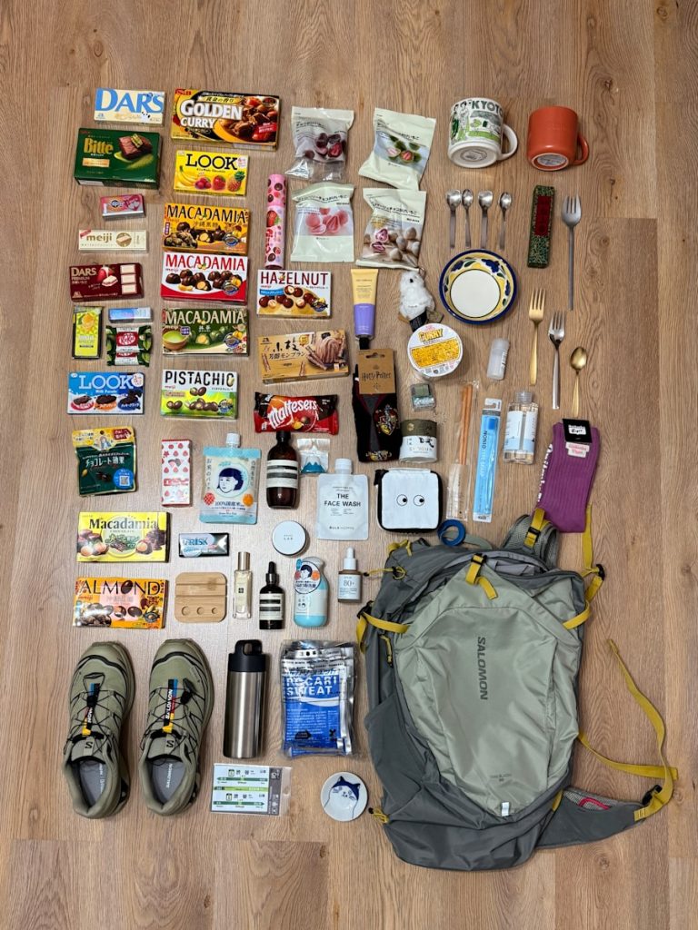 Various items laid out with a backpack and shoes.
