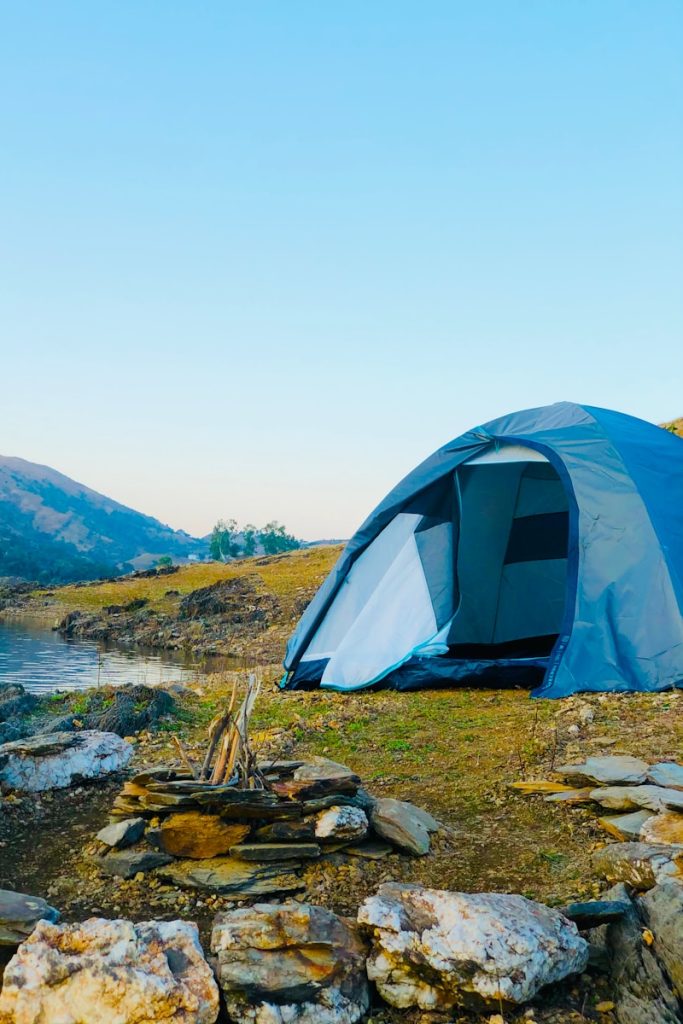 white dome tent on green grass field near body of water during daytime