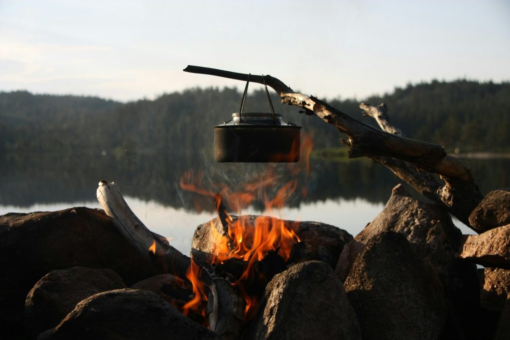 Top 5 Best Camping Stoves for 2026: From Family Feasts to Solo Treks a campfire with a pot hanging over it