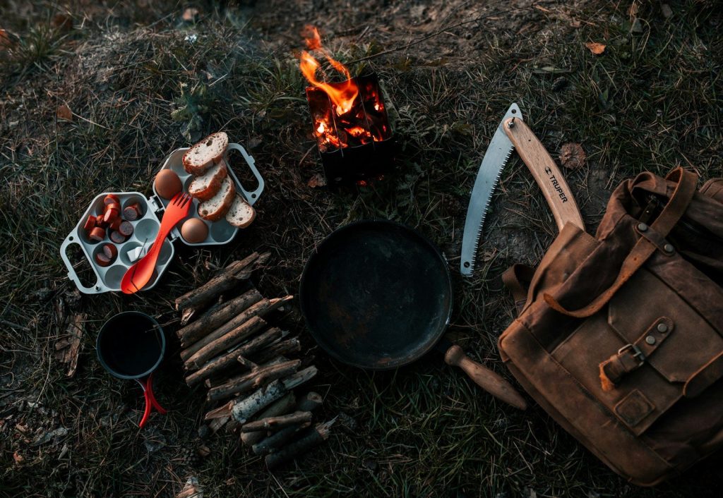 a campfire with a bunch of cooking utensils