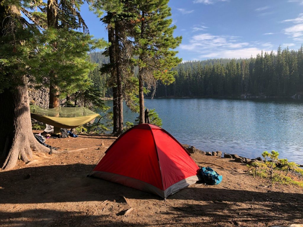 red and black tent near lake during daytime