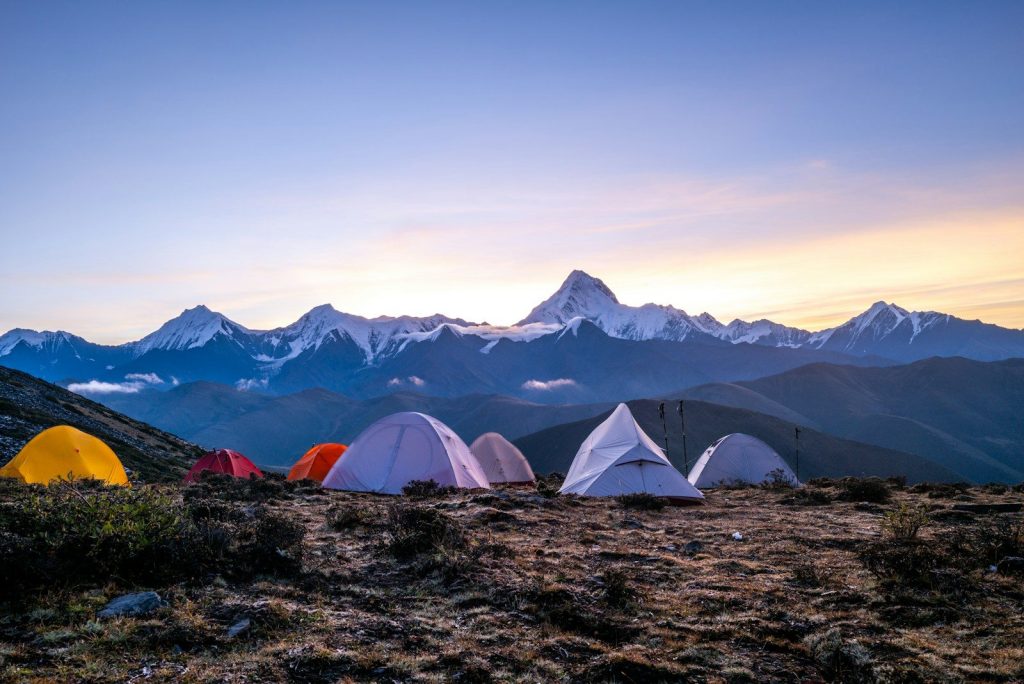Best Camping Destinations for Families Tents set up on a mountain ridge at dawn.