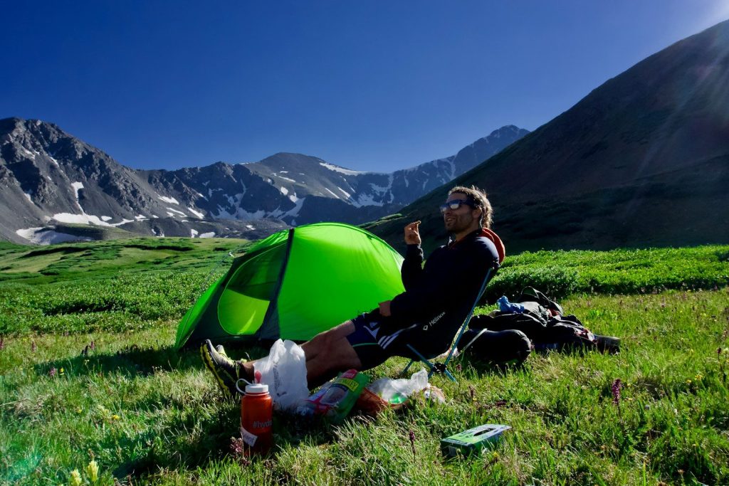 Best Sun Protection Clothing: Stay Safe and Comfortable Under the Sun man sitting on black camping chair beside green dome tent