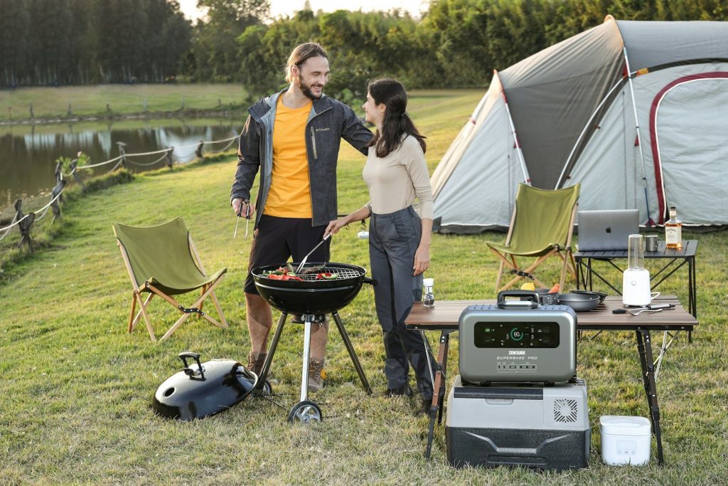 a man and a woman standing next to a grill