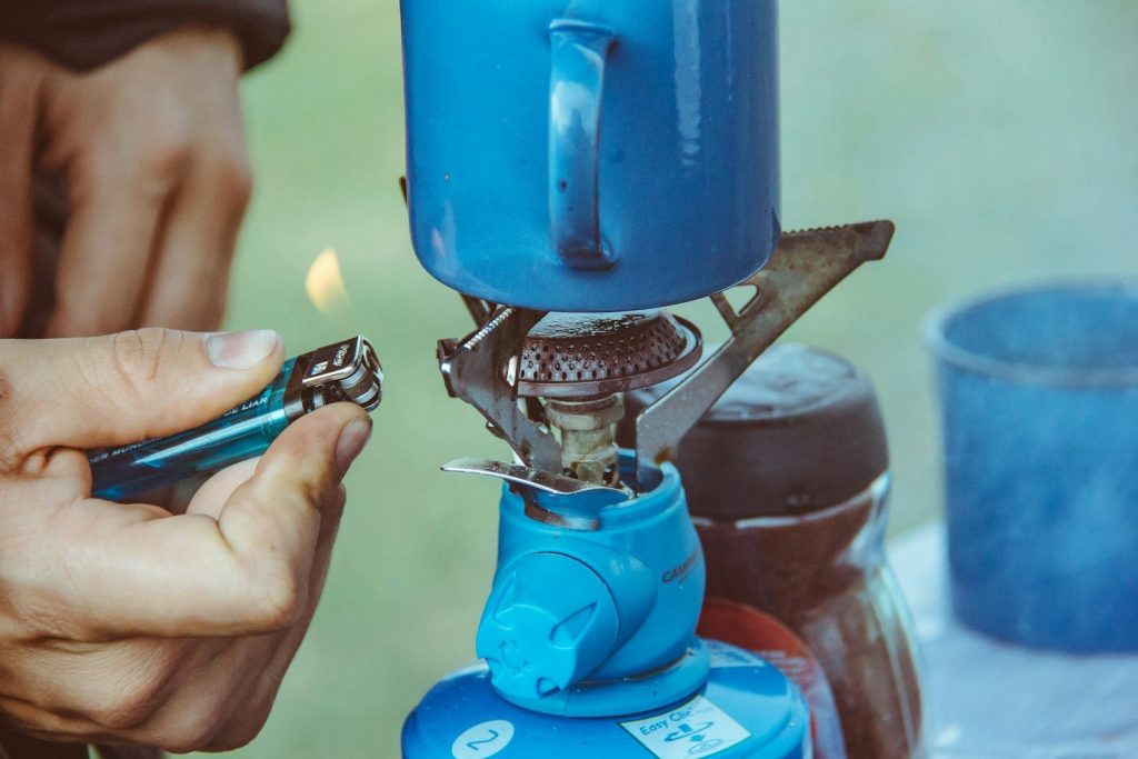 Gas vs Liquid Fuel Stoves: The Ultimate Backcountry Comparison person lighted single burner using lighter