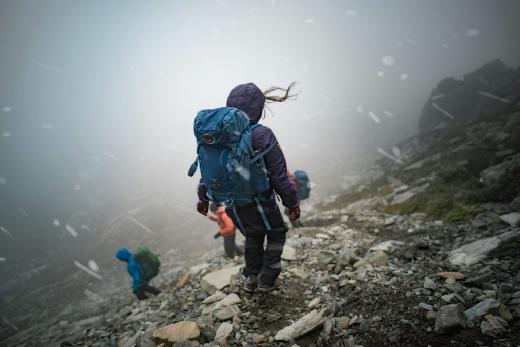 Best Waterproof Hiking Backpacks: Vetted Storm-Proof Trail Packs a person with a backpack walking up a rocky hill
