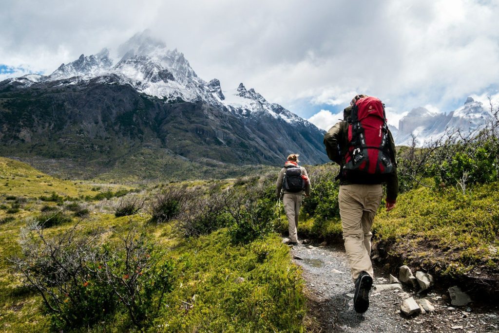 Best Budget Hiking Clothing: Vetted High-Performance Tech Under $40 two person walking towards mountain covered with snow