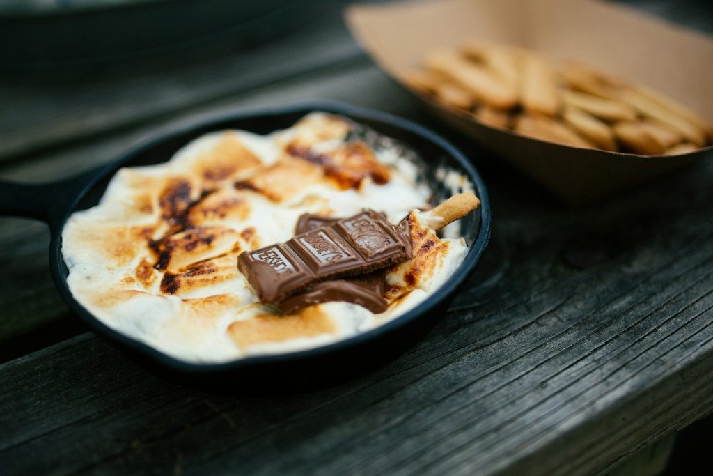 a pan filled with food next to a bowl of crackers
