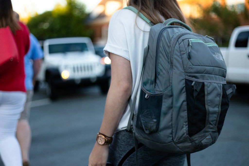 Best Carry-On Backpacks for Travel: Vetted One-Bag Airport Fortresses woman using gray backpack